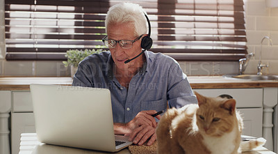 Buy stock photo Laptop, cat and man with headset in home with customer service consultation for online crm. Technology, pet and mature male technical support or telemarketing agent working on computer in kitchen.