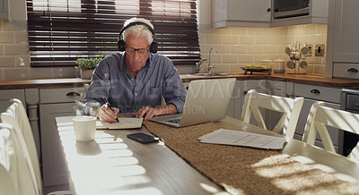 Buy stock photo Computer, writing and senior man with headphones in home planning retirement fund, finance or saving. Technology, notebook and person with laptop for online mortgage, debt or bills payment in kitchen