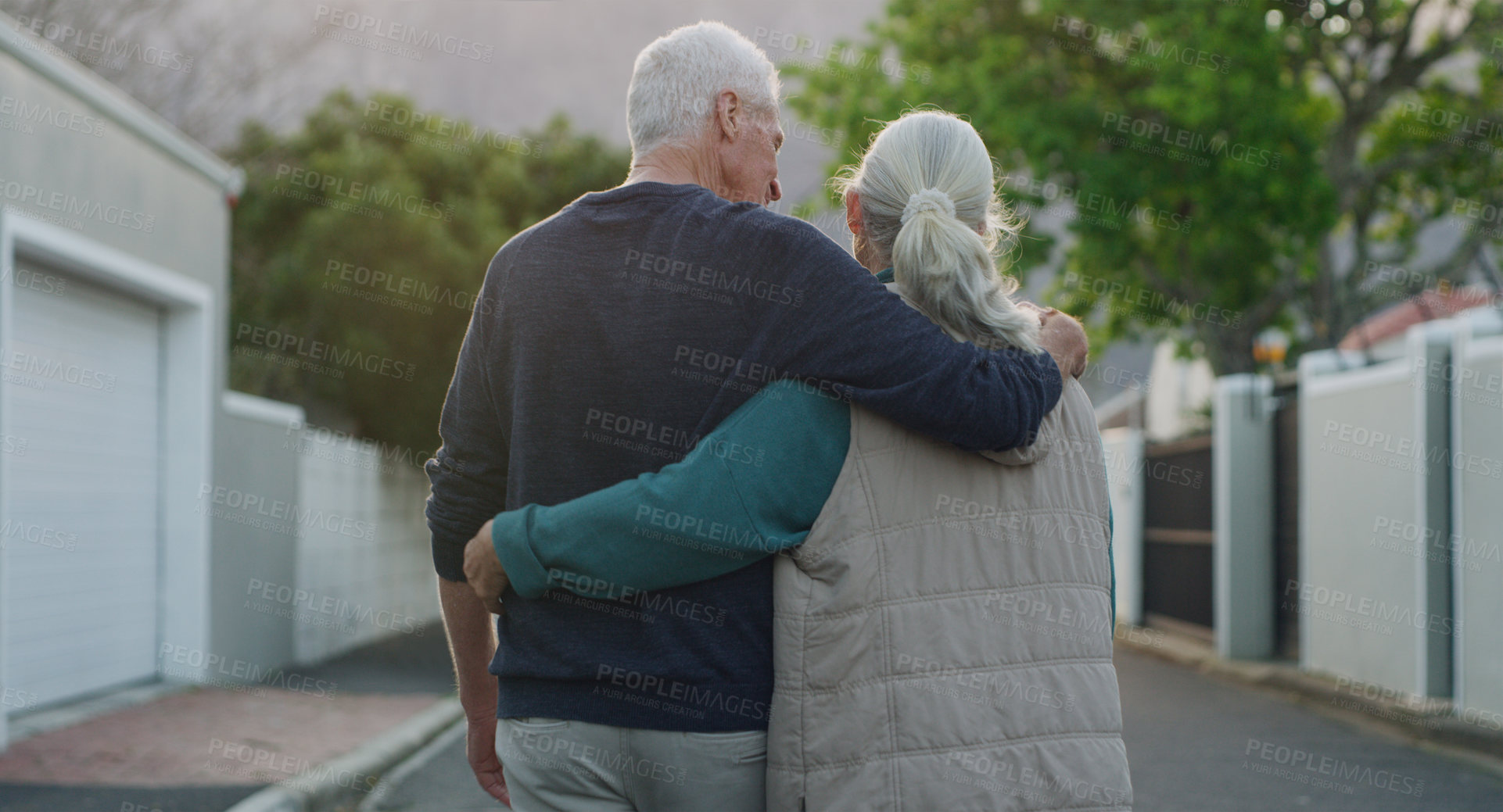 Buy stock photo Senior couple, walk and hug outdoor in city, road and driveway of house for love, peace and support. Elderly people, freedom and retirement together in nature, environment or urban with back view