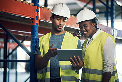 Buy stock photo Shot of two builders using a digital tablet while working at a construction site