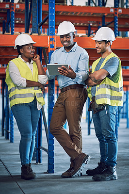 Buy stock photo Shot of a group of builders using a digital tablet while working at a construction site