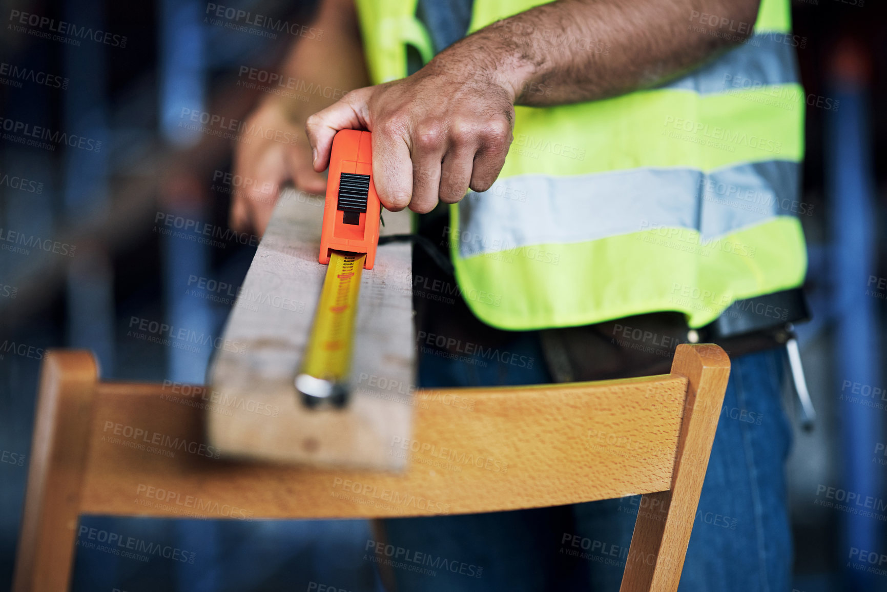 Buy stock photo Shot of a builder using a measuring tape at a construction site