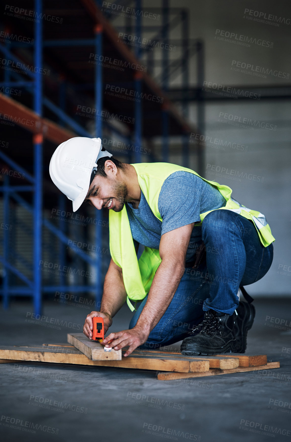 Buy stock photo Shot of a young builder using a measuring tape at a construction site