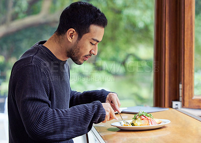 Buy stock photo Shot of a man enjoying a plate of food in a cafe
