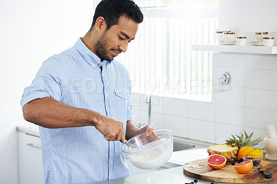 Buy stock photo Shot of a man making himself a smoothie at home