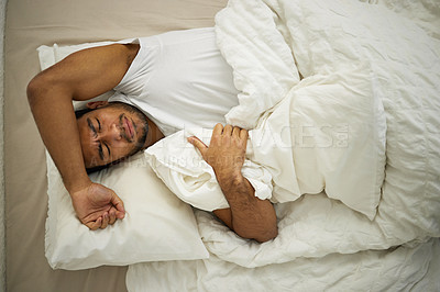 Buy stock photo Sleeping problem, headache and man rest in bed with pillow at home with insomnia and fatigue. Morning, male person and house feeling frustrated from pain and sleep issue with blanket in bedroom