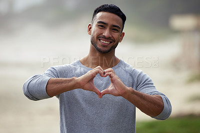 Buy stock photo Portrait of happy man, heart and hand outdoor for care, kindness and emoji for charity, mental health and joy. Young guy, self love and finger shape of hands for thank you, trust and hope with smile