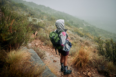 Buy stock photo Shot of a woman wearing her rain jacket while out hiking