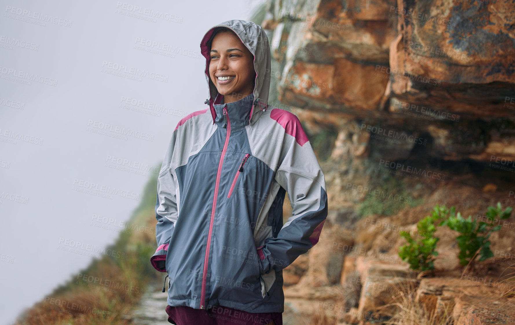 Buy stock photo Woman, outdoor or smile for hiking in rain with fashion, freedom and exercise for wellness. Female person, nature or walk on mountain for adventure with jacket, clothes for active lifestyle or travel