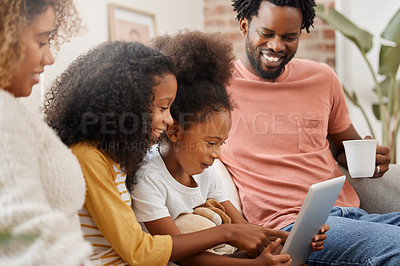 Buy stock photo Shot of a young family spending time together and using a digital tablet at home