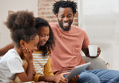 Buy stock photo Shot of a young family spending time together and using a digital tablet at home