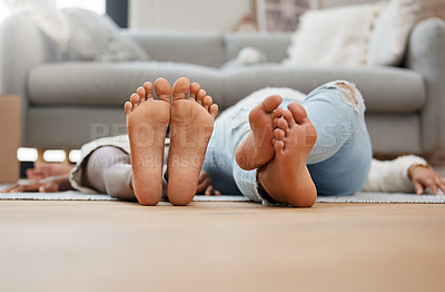 Buy stock photo Shot of tow unrecognizable people laying on the floor at home