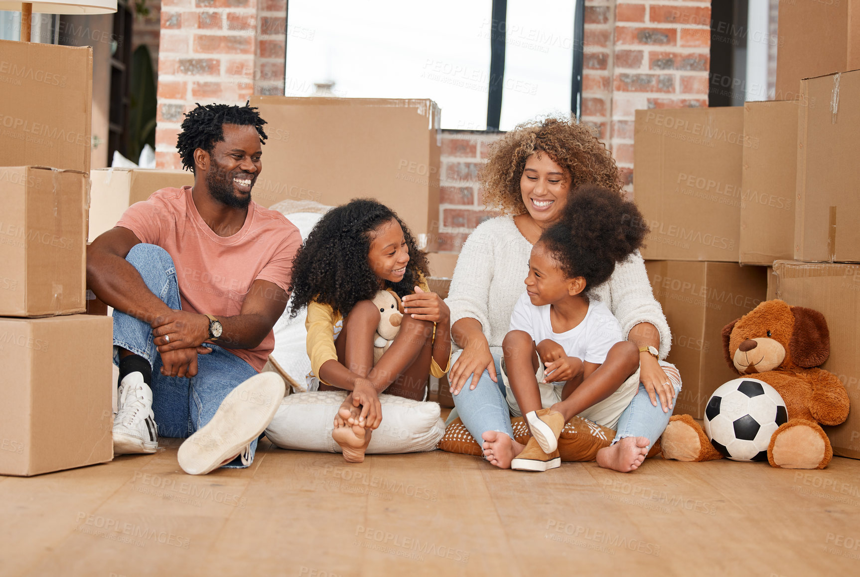 Buy stock photo Shot of a family sitting on the floor in their new home