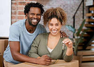 Buy stock photo Shot of a young couple showing keys to their new home