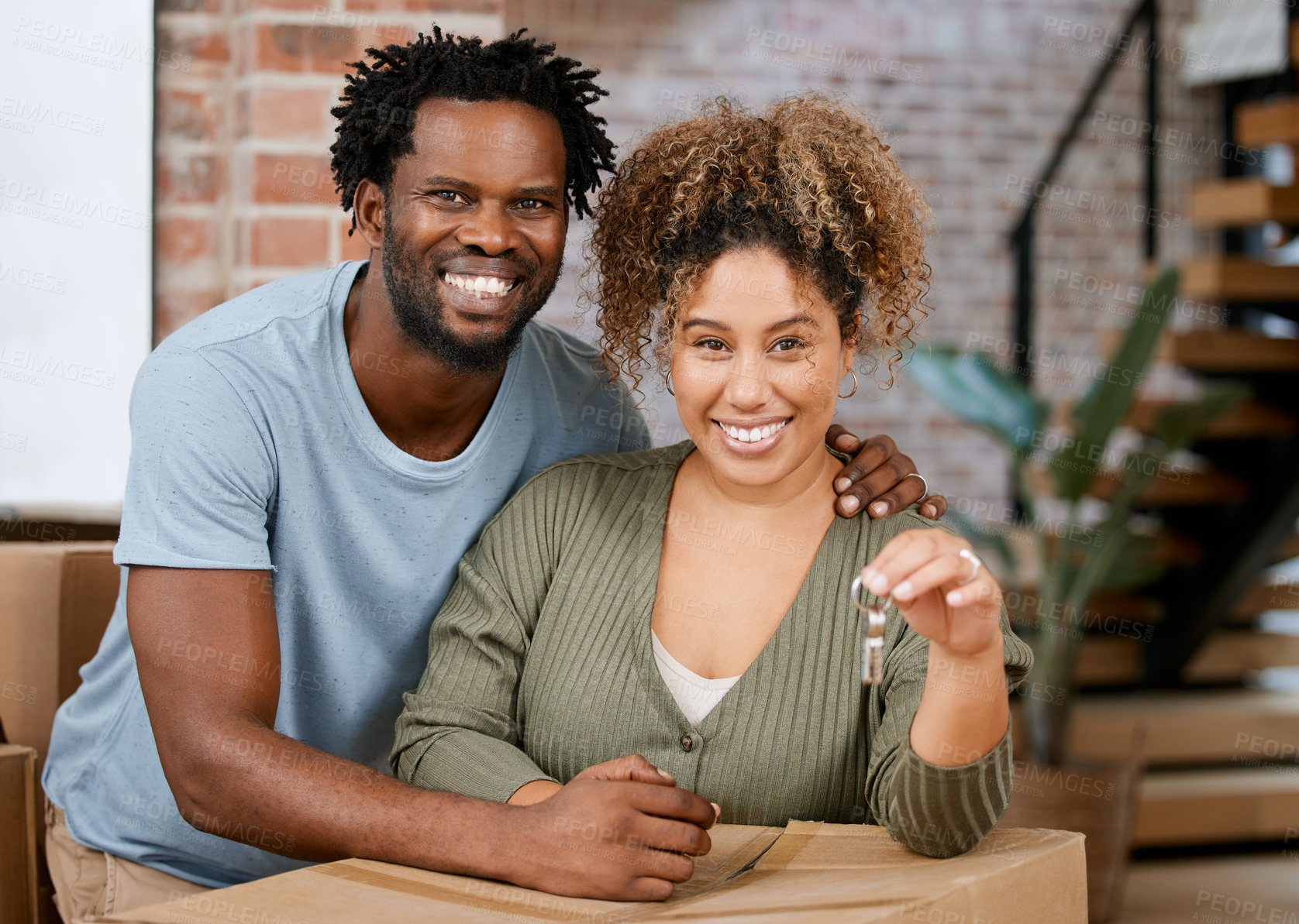 Buy stock photo Shot of a young couple showing keys to their new home