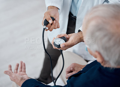 Buy stock photo Shot of an unrecognizable doctor checking a patient's blood pressure in an office