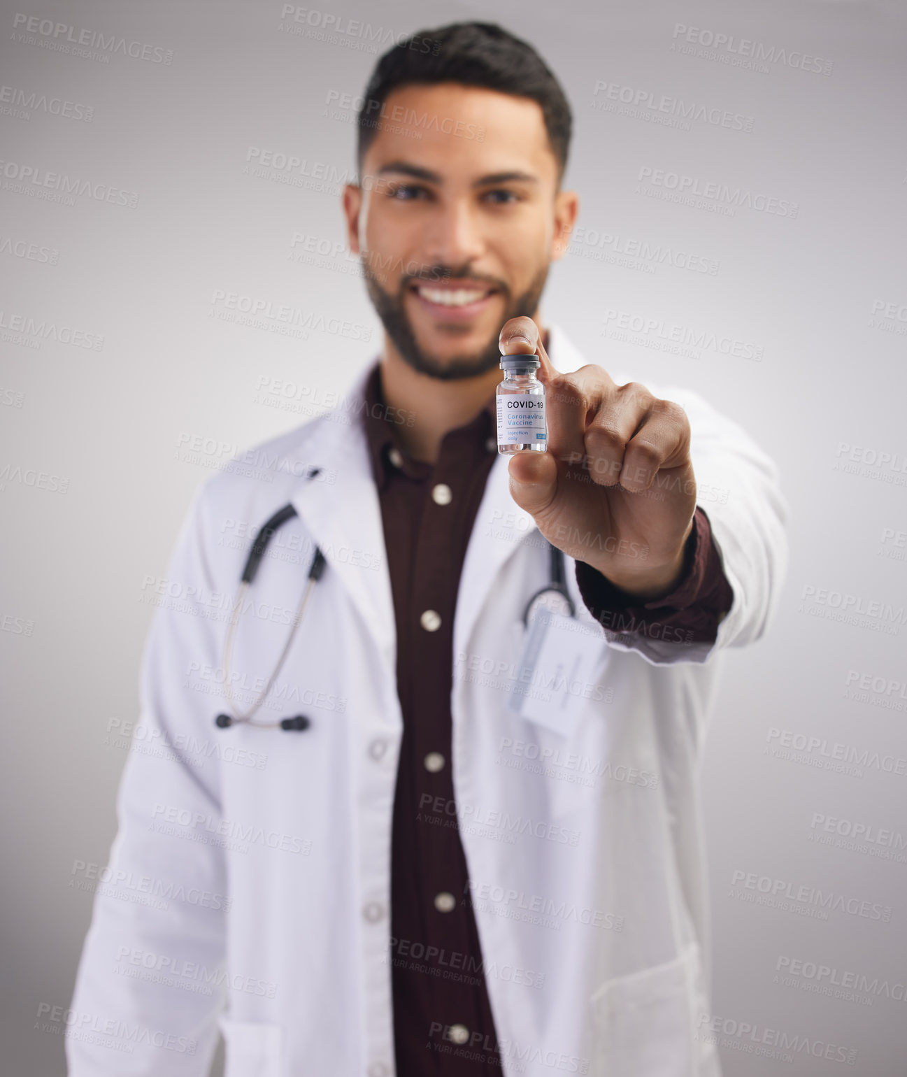 Buy stock photo Portrait, doctor and holding vaccine in studio for healthcare, medical and man in lab coat by grey background. Professional male person, stethoscope and bottle in clinic with pride for medicine 