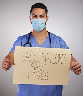 Buy stock photo Shot of a handsome young nurse standing in the studio and holding up a poster while wearing a face mask