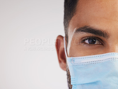 Buy stock photo Cropped shot of an unrecognizable nurse standing alone in the studio and wearing a face mask