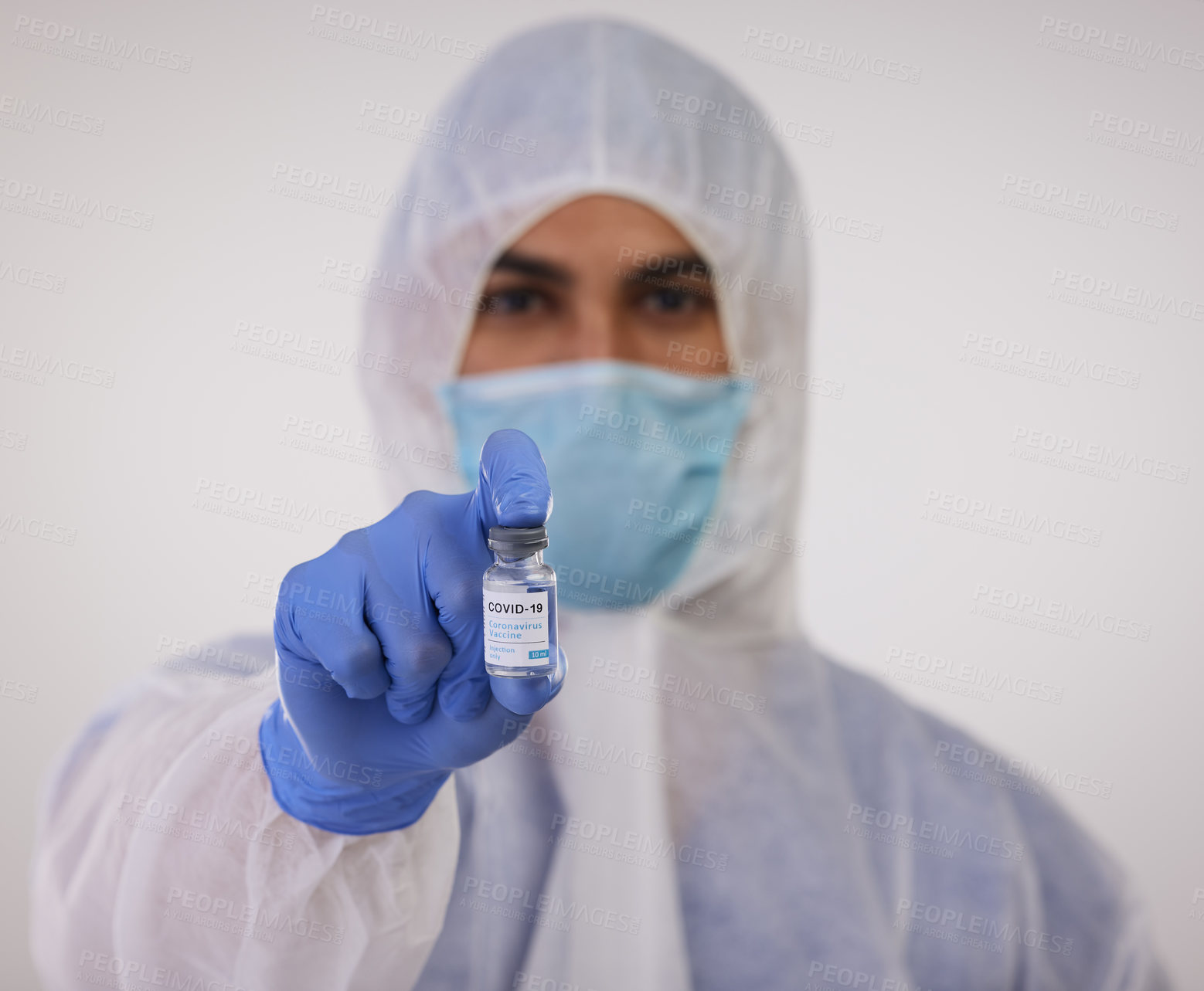 Buy stock photo Shot of a medical professional standing in a disposable hazmat suit and holding a vial for the Covid vaccine