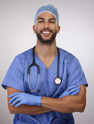 Buy stock photo Shot of a handsome young nurse standing alone in the studio with his arms folded