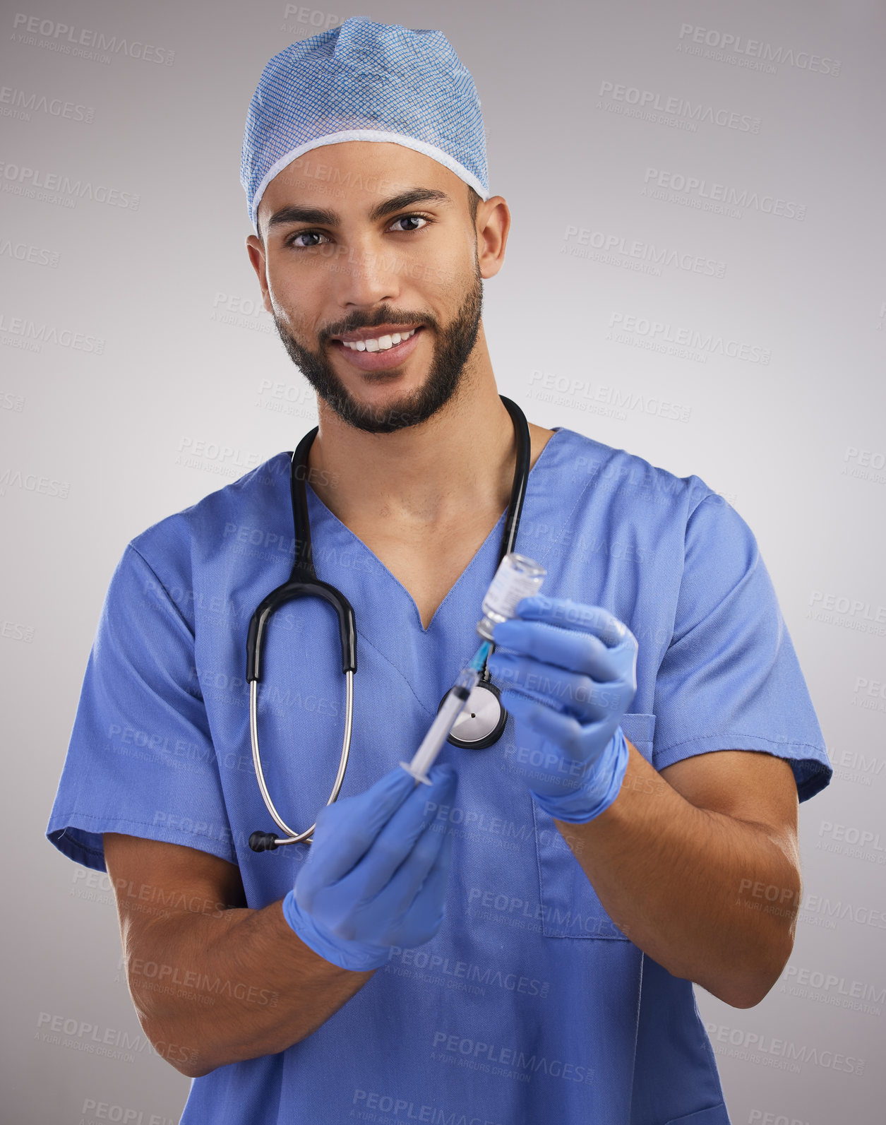 Buy stock photo Shot of a handsome young nurse standing alone and using a syringe to prepare a Covid vaccination