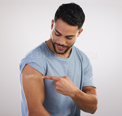 Buy stock photo Shot of a handsome young man sitting alone in the studio after getting vaccinated
