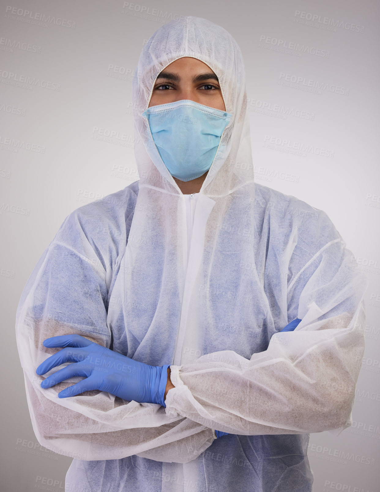 Buy stock photo Shot of a medical professional standing in a disposable hazmat suit with his arms folded