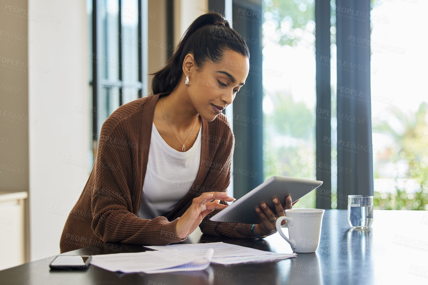 Buy stock photo Technology, woman with tablet and documents paying her bills online at her home. Payment or banking, budget or internet connectivity and female person with paper on kitchen counter of her house