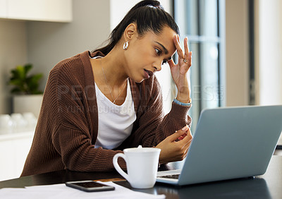 Buy stock photo Shot of a young woman looking stressed while working on her laptop at home