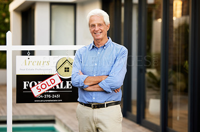 Buy stock photo Cropped portrait of a handsome senior man standing with his arms crossed next to a sold sign outside of his newly purchased home