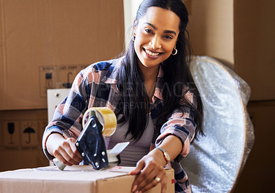 Buy stock photo Shot of a young woman packing up to move