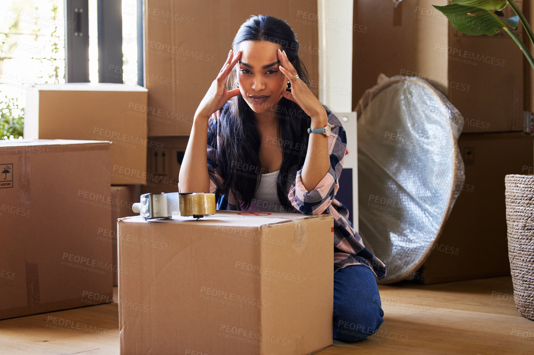 Buy stock photo Shot of a young woman packing up to move