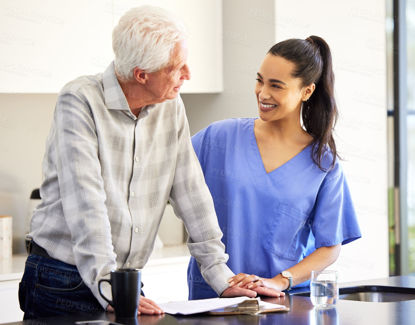 Buy stock photo Home, senior patient and nurse for support, consultation and communication with smile in kitchen. House, elderly man and caregiver for helping, assistance and healthcare paperwork or document