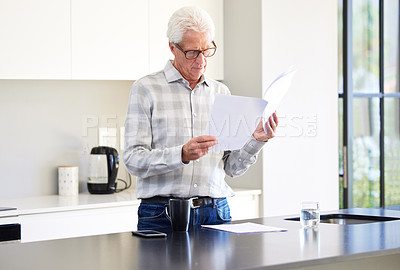 Buy stock photo Shot of a mature man reading paperwork