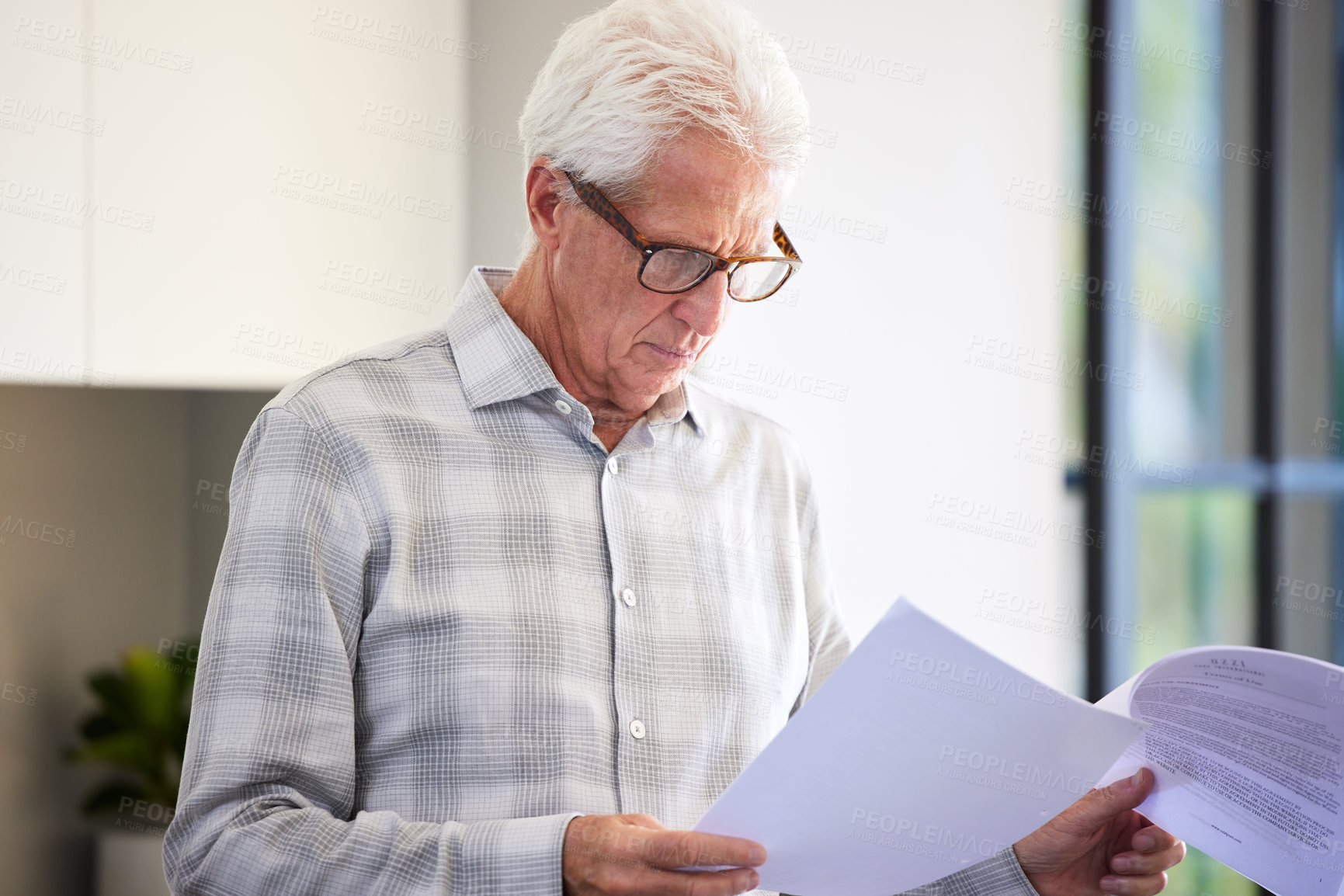 Buy stock photo Shot of a mature man reading paperwork