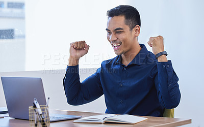 Buy stock photo Shot of a young businessman cheering while working on a laptop in an office