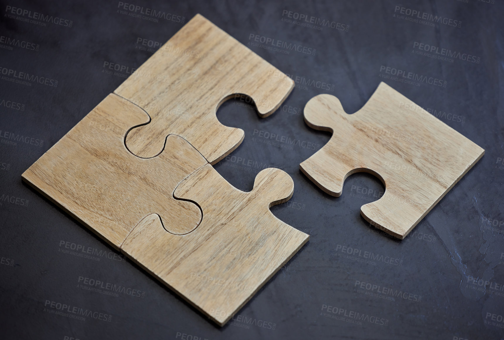Buy stock photo Shot of puzzle pieces lying on a desk in an empty office during the day
