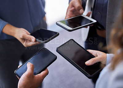 Buy stock photo Cropped shot of an unrecognizable group of businesspeople standing together in the office and using their cellphones