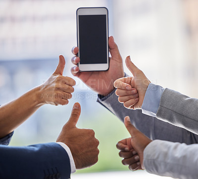 Buy stock photo Cropped shot of an unrecognizable group of businesspeople standing with their thumbs up while a coworker holds a cellphone