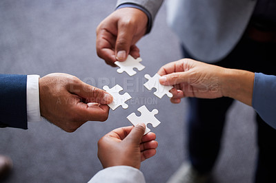 Buy stock photo Cropped shot of four businesspeople holding puzzle pieces together