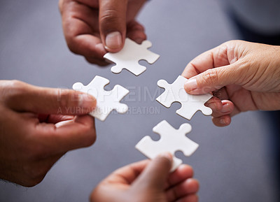Buy stock photo Cropped shot of four businesspeople holding puzzle pieces together