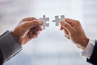 Buy stock photo Cropped shot of two businesspeople holding puzzle pieces together