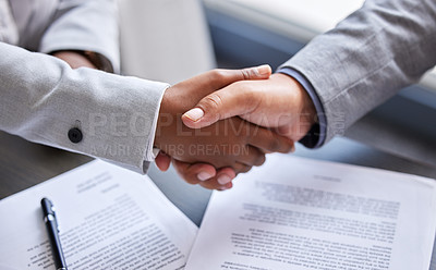 Buy stock photo Cropped shot of two businesspeople shaking hands during a meeting in an office