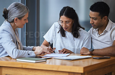 Buy stock photo Shot of a young couple meeting with a consultant to discuss paperwork an office