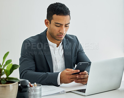 Buy stock photo Shot of a businessman using a smartphone at his desk in a modern office