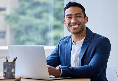 Buy stock photo Shot of a young businessman working on his laptop