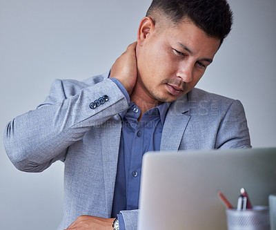 Buy stock photo Shot of a young businessman experiencing neck pain at work