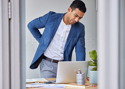 Buy stock photo Shot of a businessman experiencing back pain at work