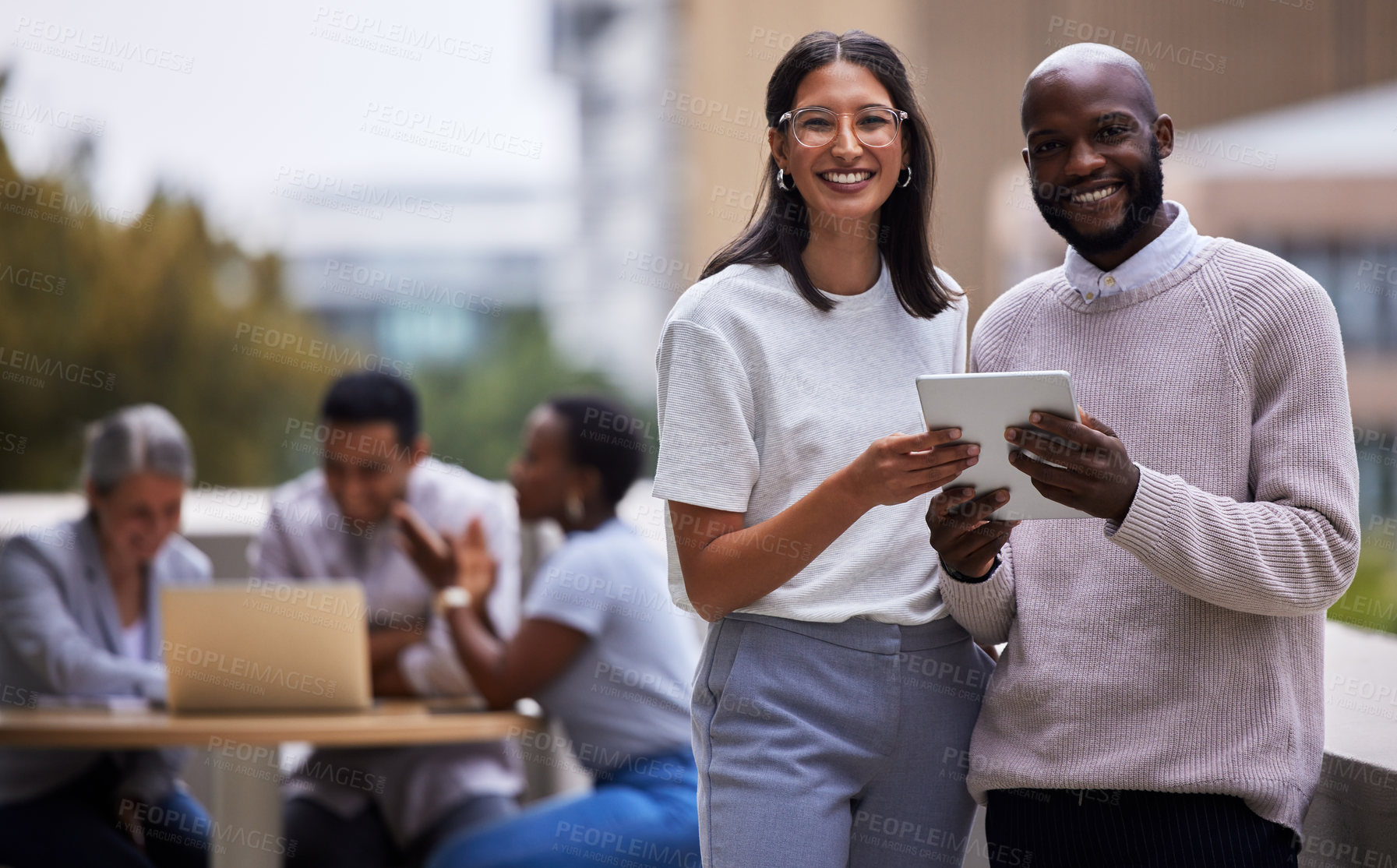 Buy stock photo Shot of two professional coworkers using a digital tablet together at work